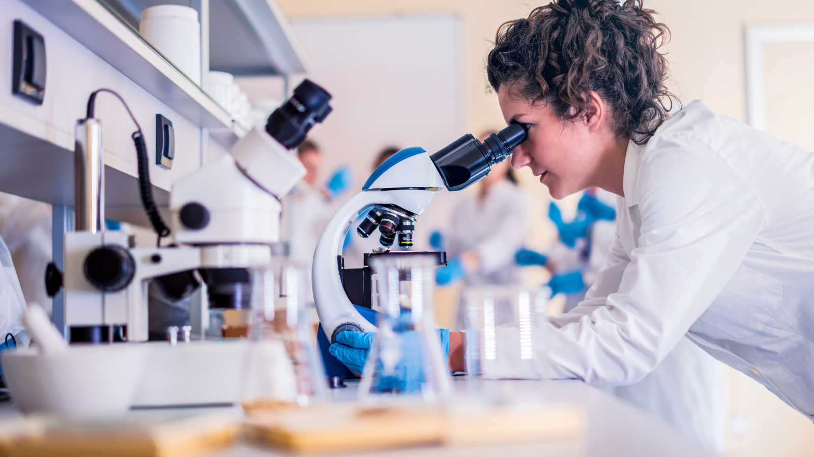 cientista num laboratório a fazer experiências num microscópio 