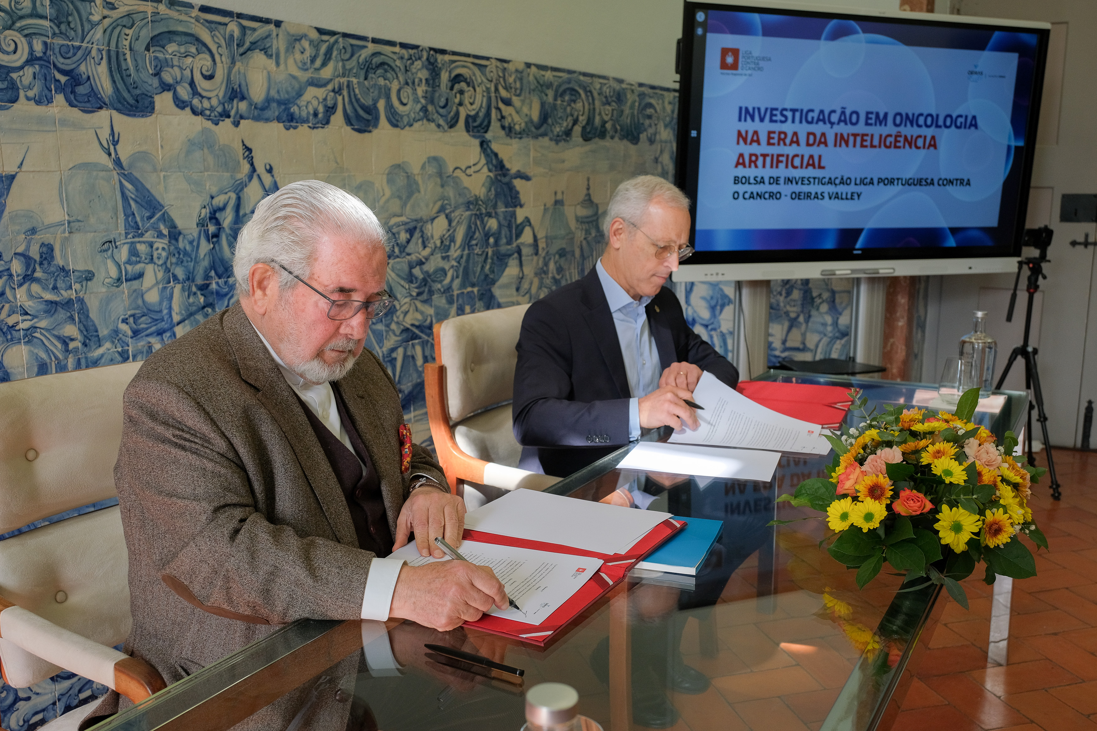 Presidente da CMO e o Presidente do Núcleo Regional do Sul da Liga Portuguesa Contra o Cancro a assinarem  o protocolo. 