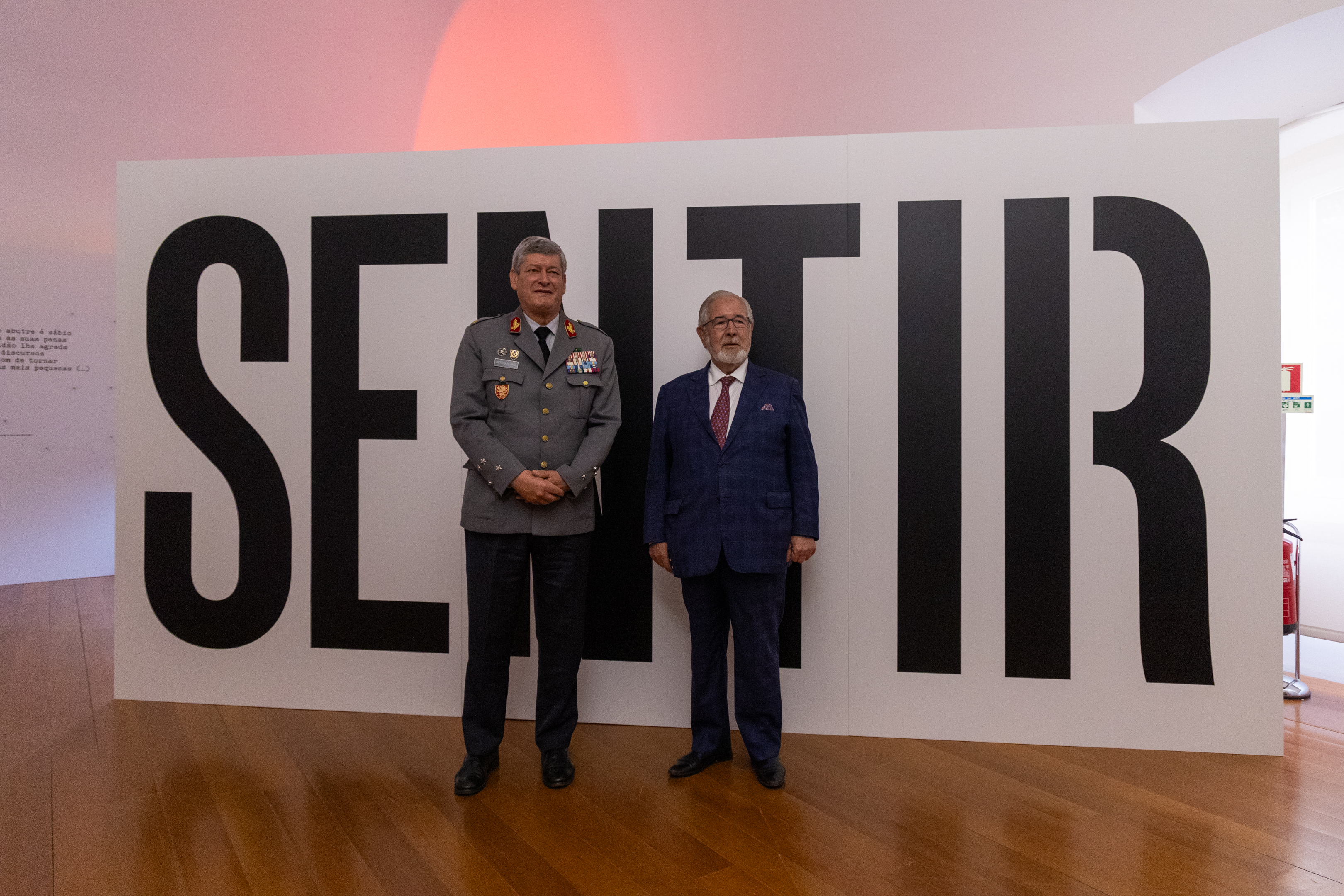 O Presidente da CMO e Chefe do Estado-Maior do Exército com uma das peças da exposição, painel com a palavra 'Sentir' como pano de fundo.  