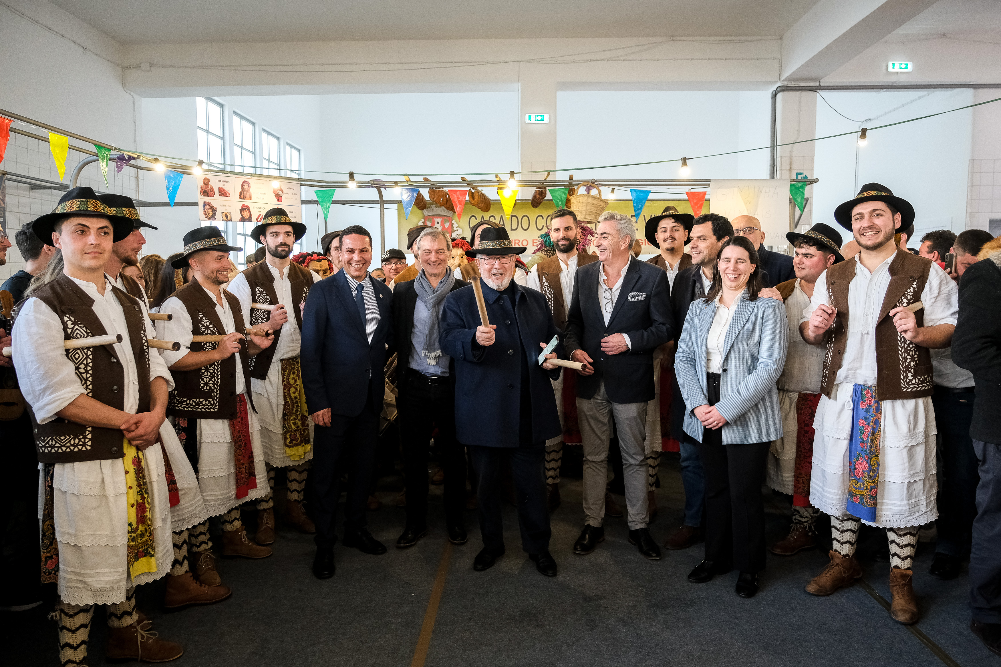 Fotografia do Presidente da CMO com os pauliteiros, acompanhado por membros do Executivo Municipal e pelo Presidente da Casa do Conselho de Vinhais em Paço de Arcos. 